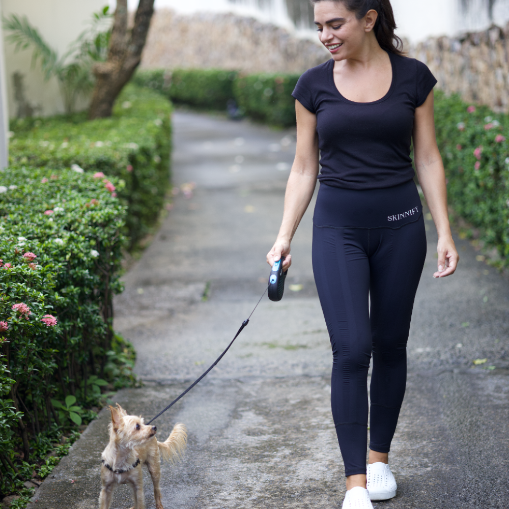 Skinnify Model geht mit dem Hund spazieren und trägt Skinnify Resistance Band Leggings
