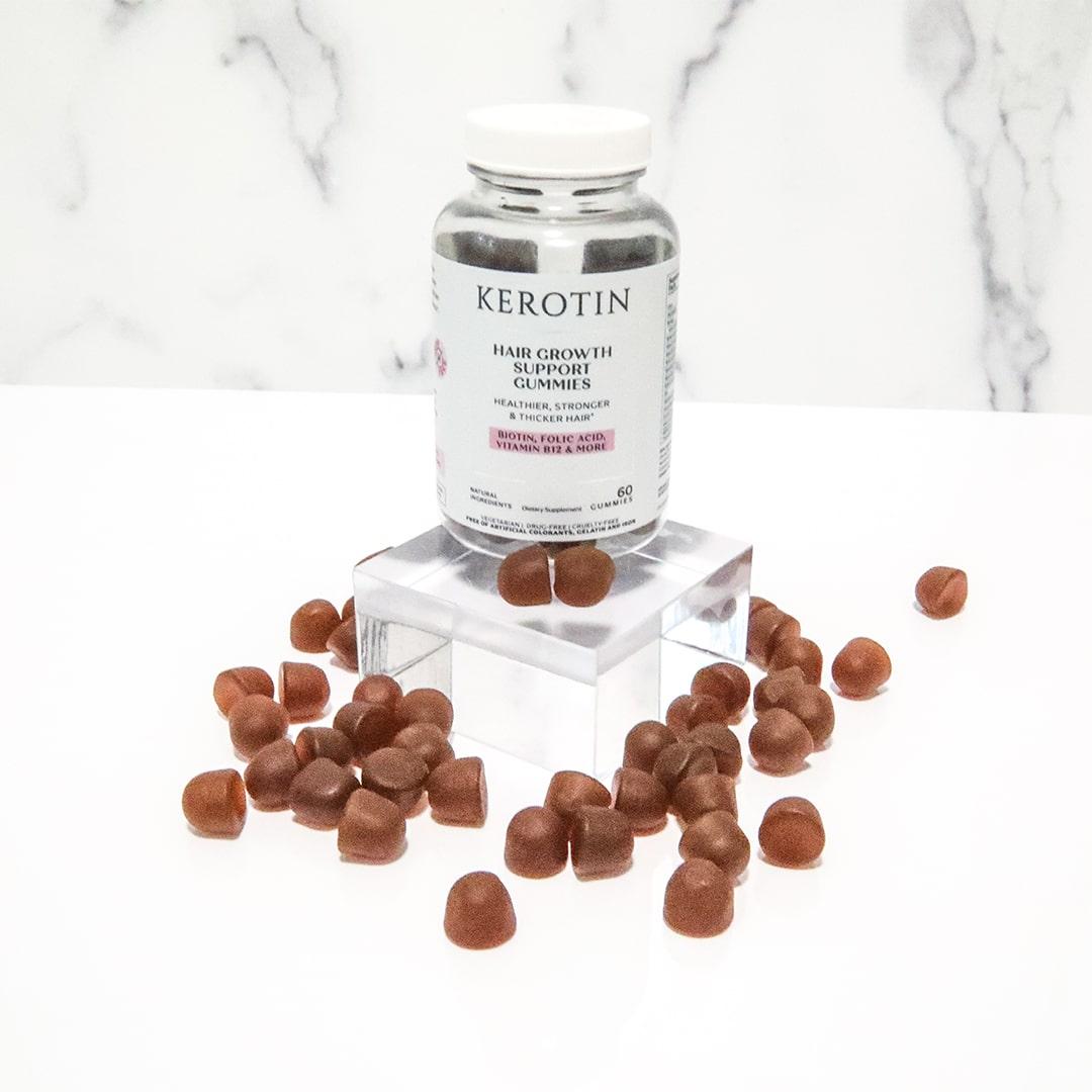 model picking a gummy from inside a bottle of Kerotin Hair Vitamin Gummies