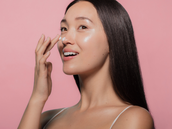 woman applying serum to her face after microneedling