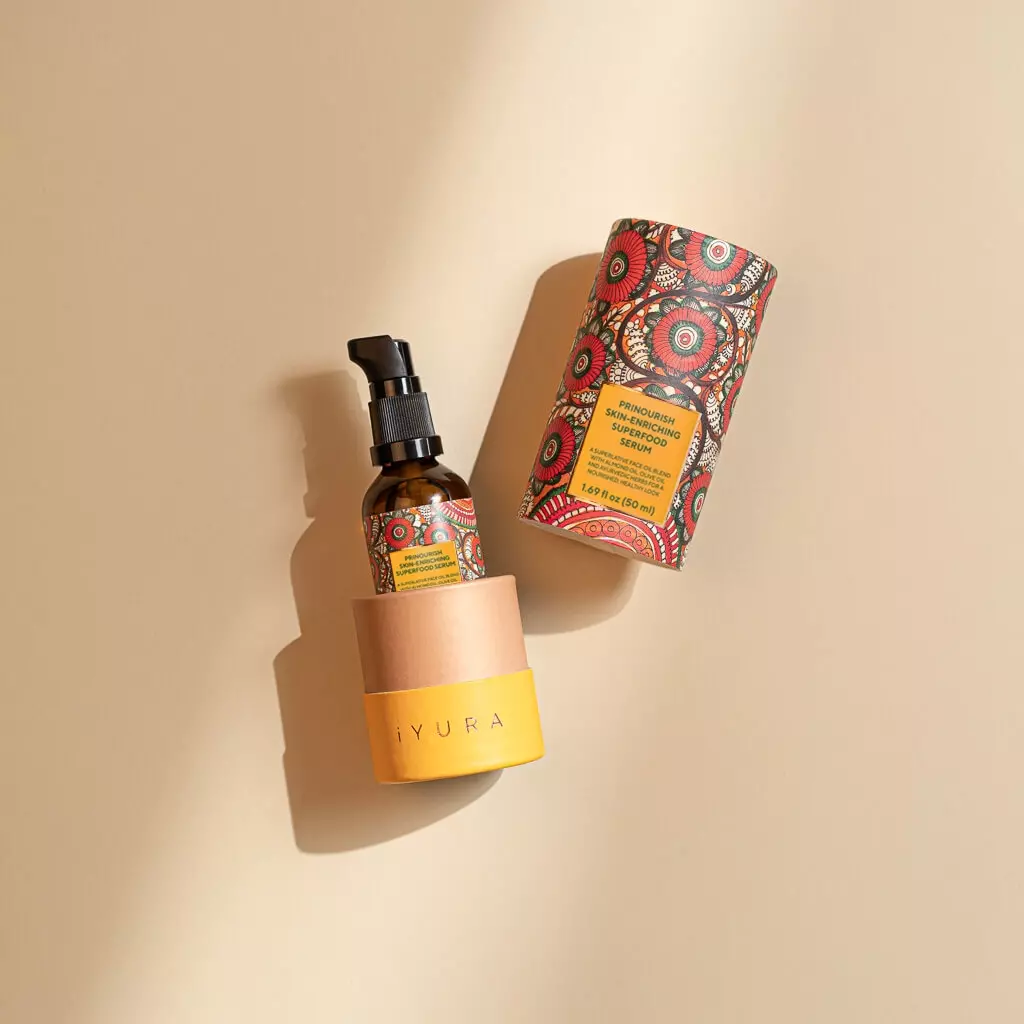A bottle of Prinourish kept inside it's beautiful, vibrant packaging, over a beige color background with beautiful sunlight