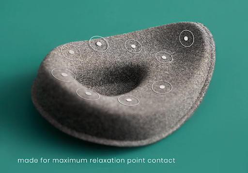 A tapered eye cup of a sleep mask with circular dots to represent pressure points.