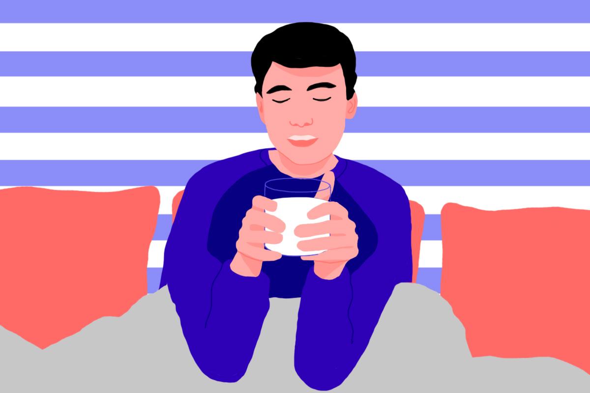 A man sitting in bed holding a glass of warm milk to help with sleep.