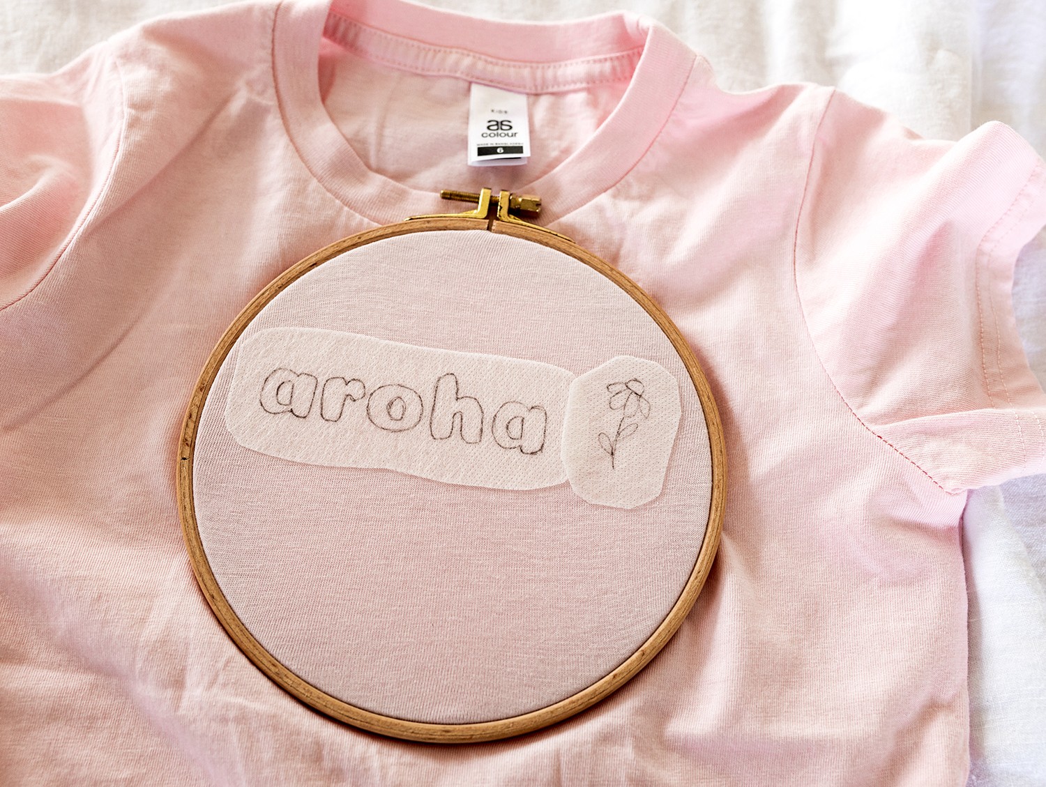 A pattern 'aroha' and a flower is placed on a tshirt.