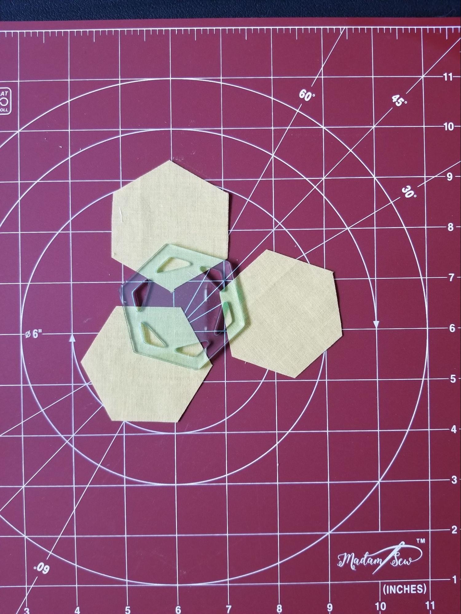 Set of hexagons that were cut from a fabric strip while using a hexagon quilt template.