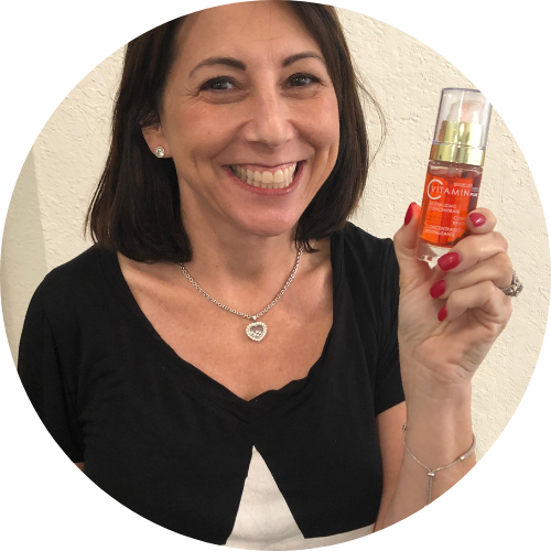 smiling customer holding Noche's Vitamin C Serum