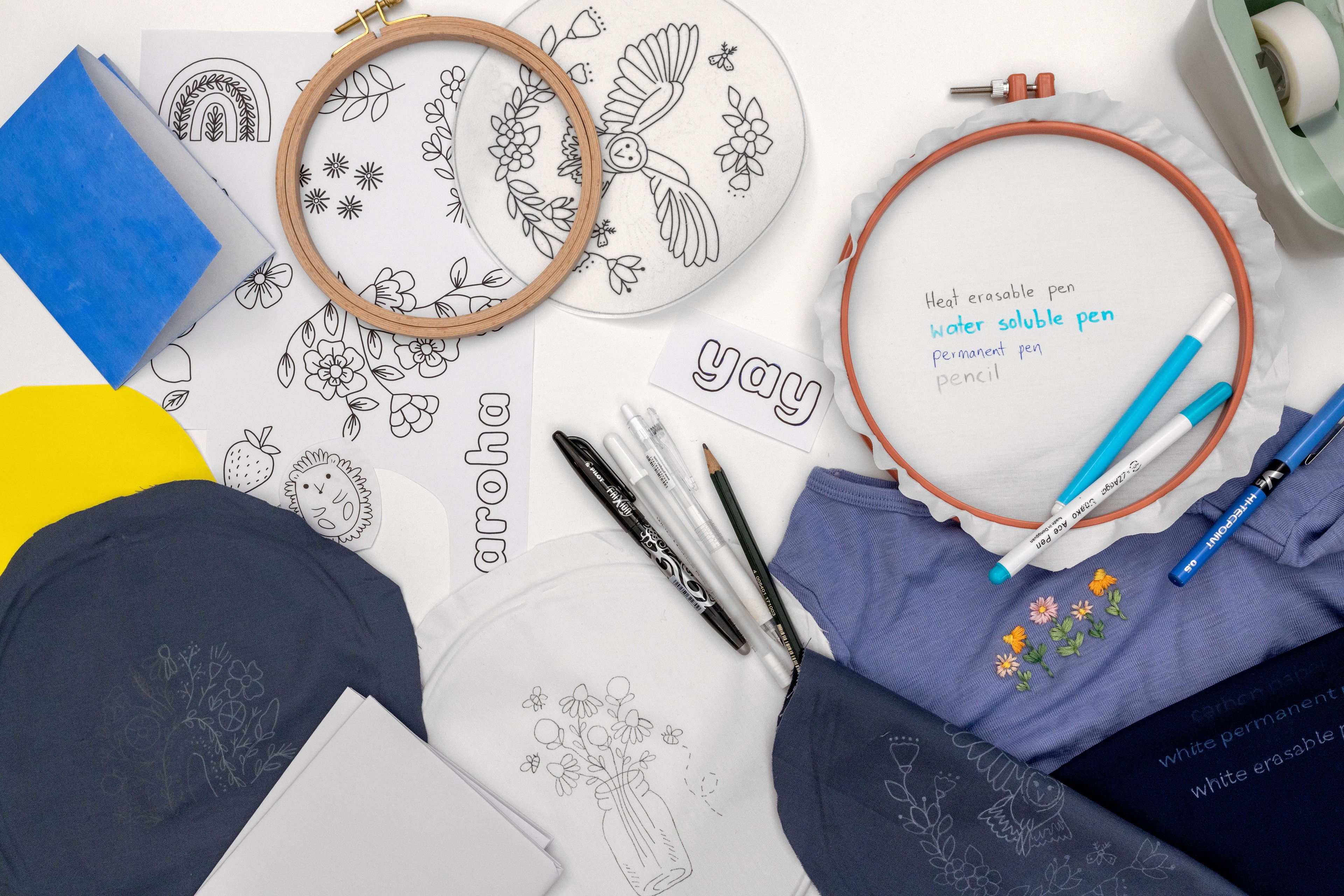This is a styled image of pens and hoops and patterns drawn on fabric.