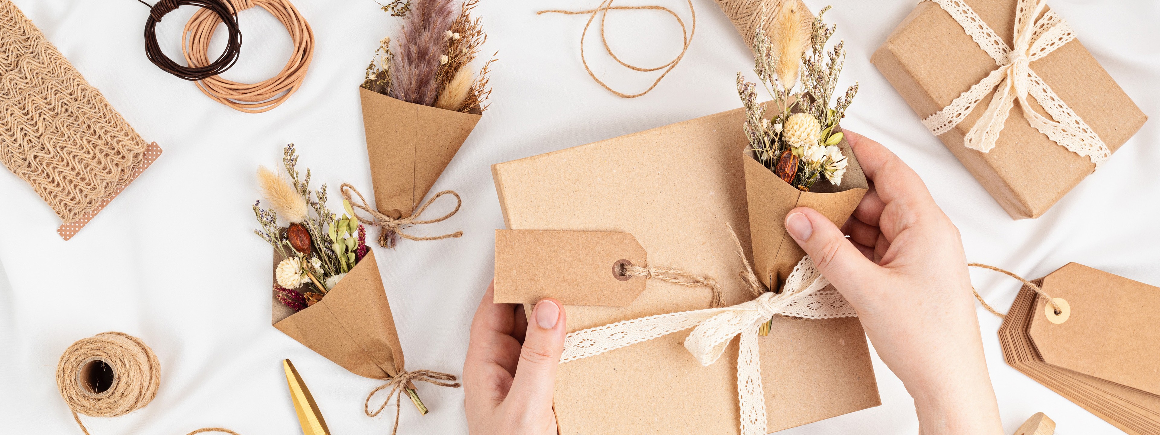 Gifts wrapped in brown paper with pine and twine and paper stars