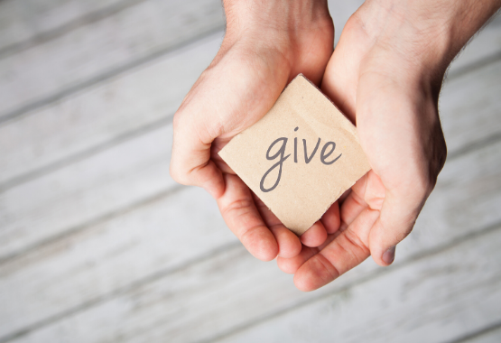 Hands with the word give on paper