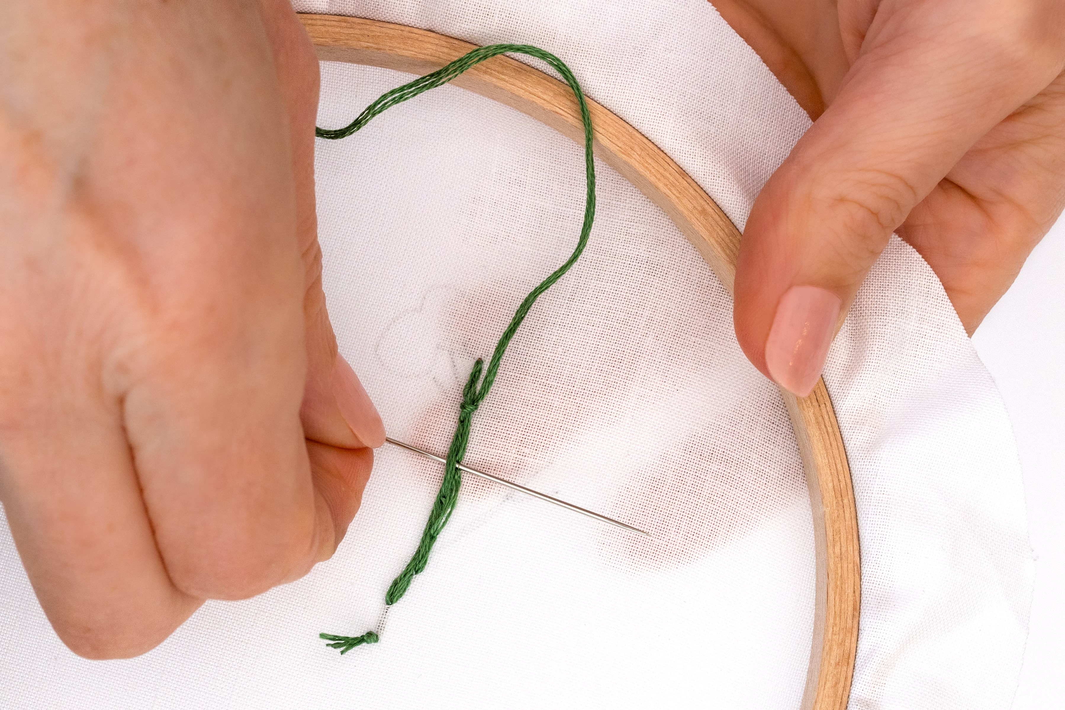 A needle goes through the back of embroidery.