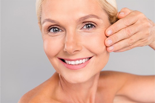 a mature woman looks happy with her skin