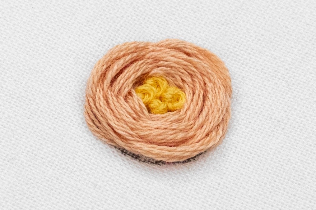 A completed woven rose has French Knot Clusters in the middle.