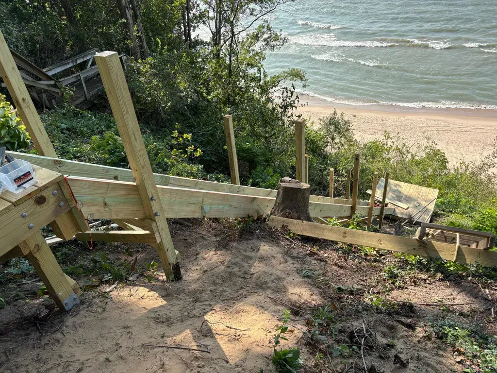 Wooden stair walkway under construction. Built on a steep down slope with the Ledger Deck Foot Anchor