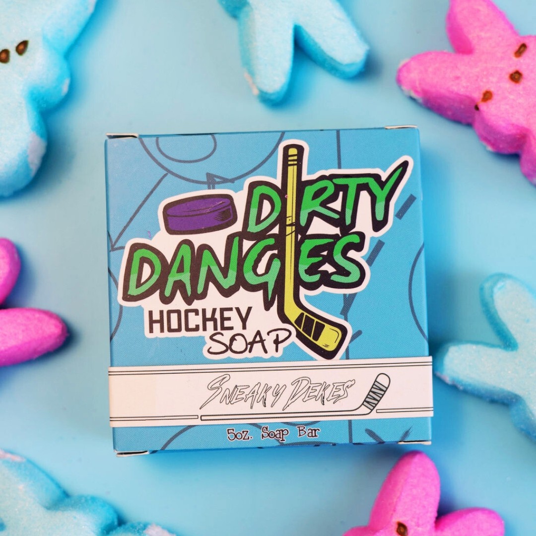 A box of sneaky dekes dirty dangles hockey soap on a blue background with blue and pink peeps bunnies
