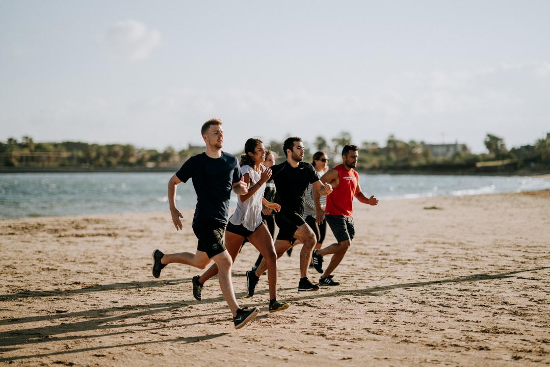A group of guys running on the beach