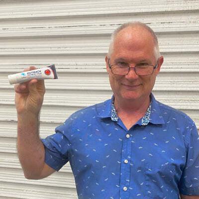 an older man holding up Outback Pain Cream