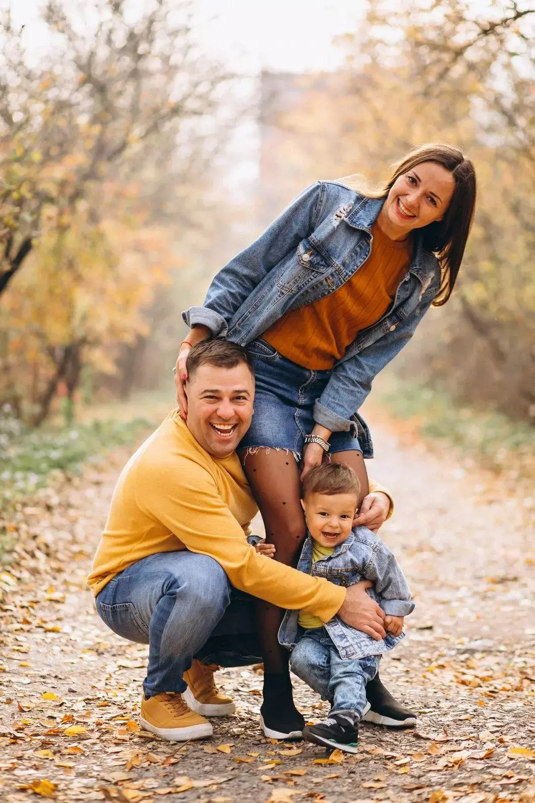“Famille souriante en promenade automnale – parents et enfant profitant de la nature, symbole de santé, bonheur et équilibre de vie”