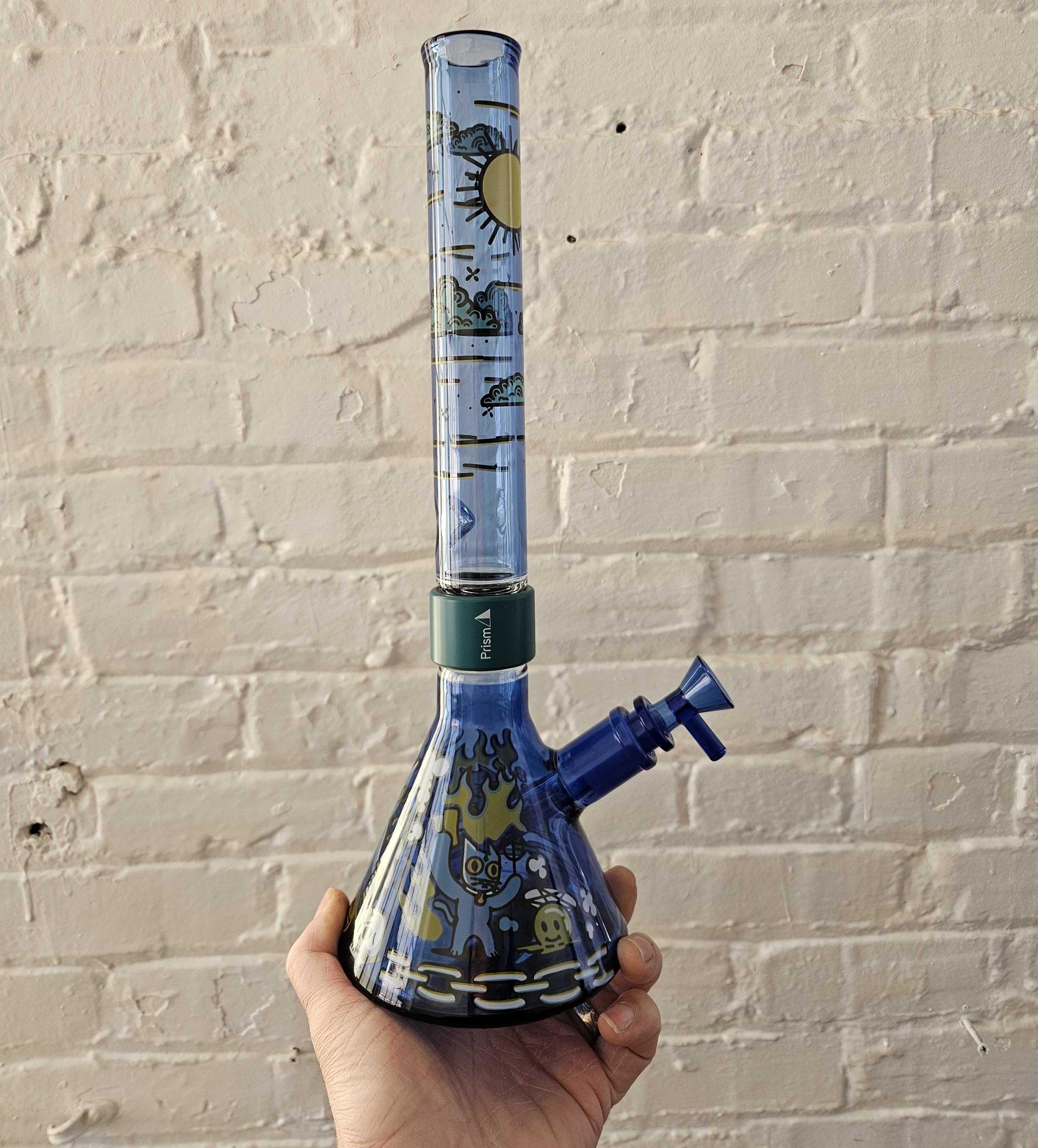 A custom sapphire blue Prism MINI modular beaker bong decorated with a unique combination of both Desert Dream'n and 666cat collection decals.