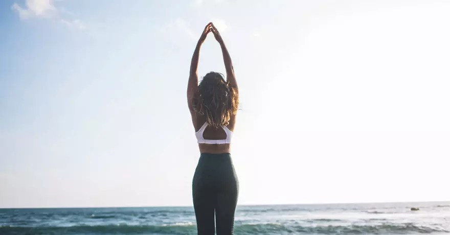woman stretching at the beach