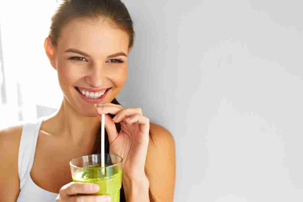 Mujer bebiendo batido verde