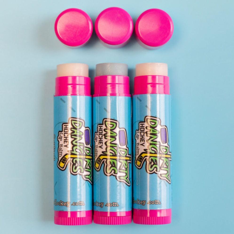 3 sticks of dirty dangles hockey lip balm open on a blue background