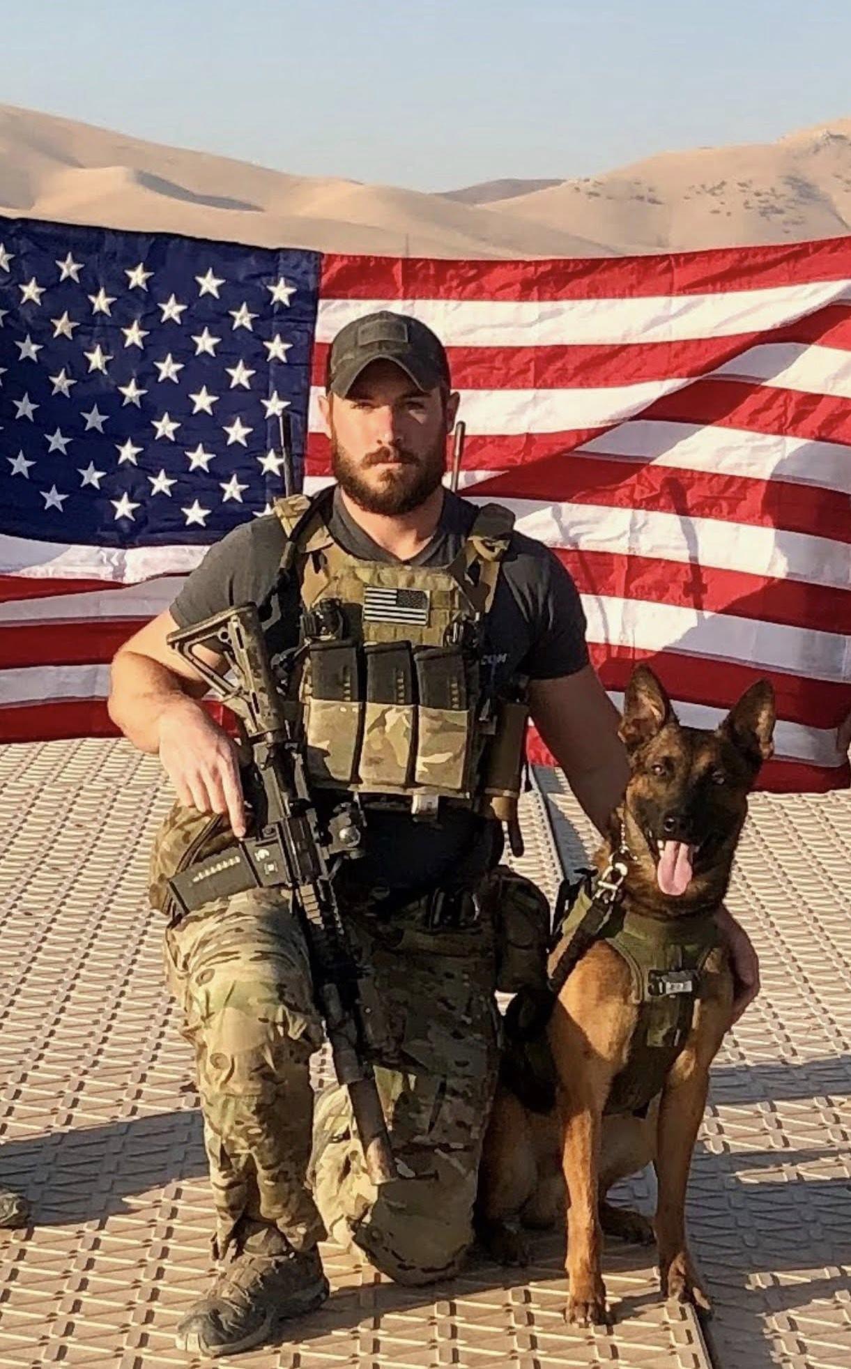 mpc thor and his handler in front of american flag int he desert