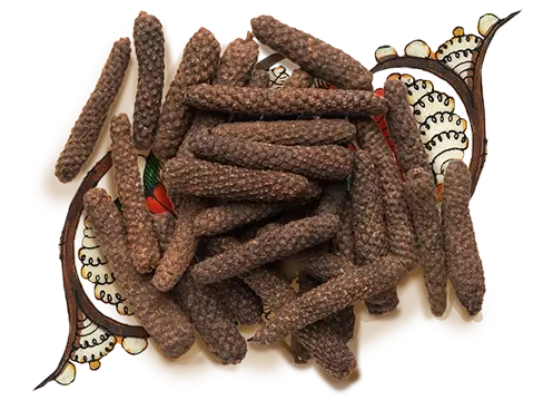 Bunch of long pepper, kept over an artwork
