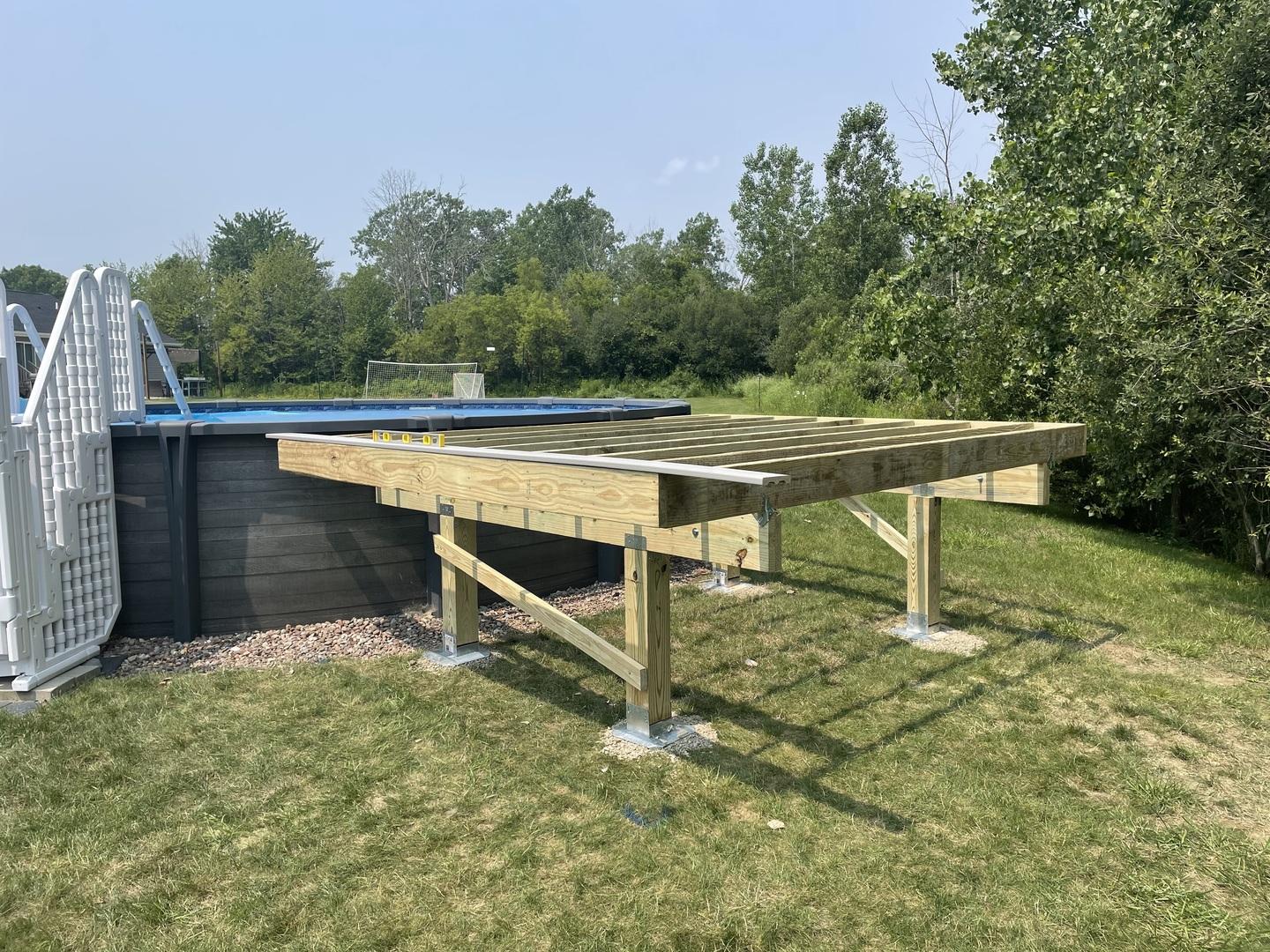 framed deck attached to pool using deck foot anchors