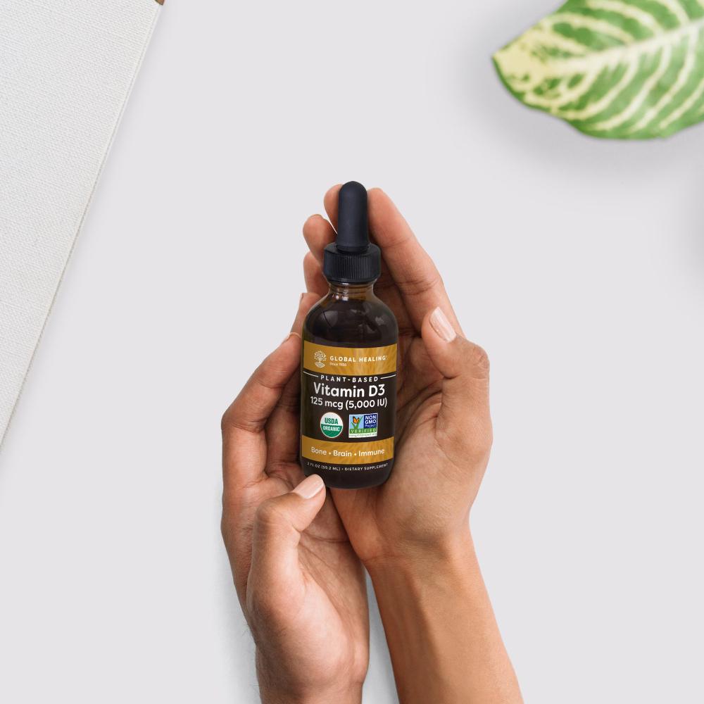 Global Healing Vitamin D3 bottle in hand