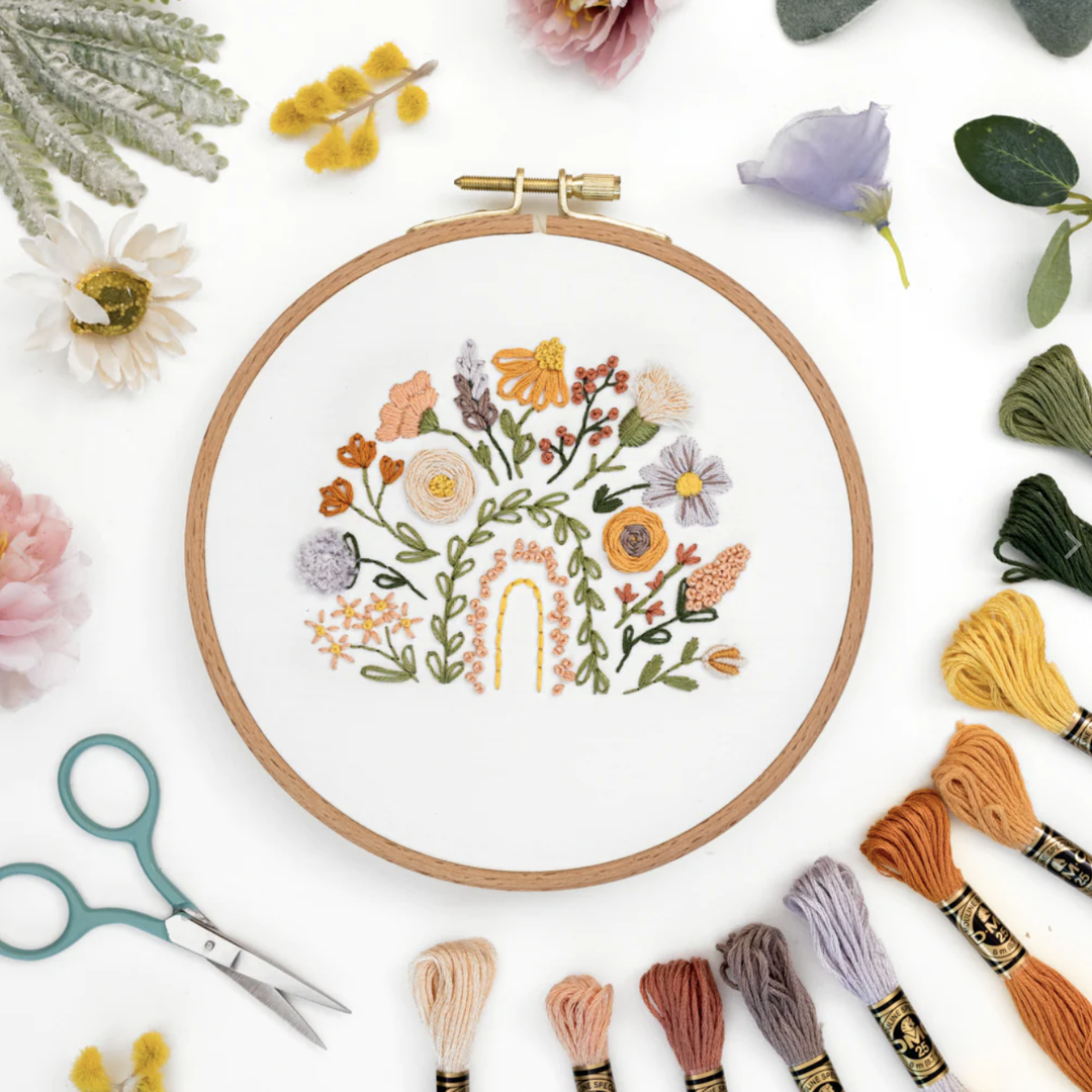 This is an image of the Floral Rainbow Sampler Pattern surrounded by props and supplies.