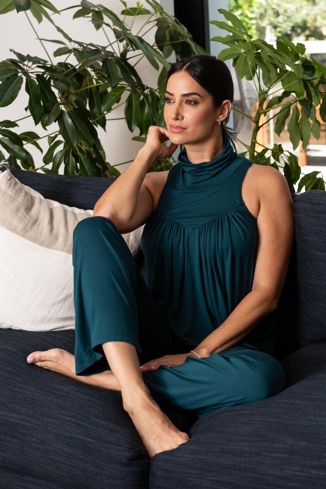 Woman on couch wearing the teal Mocktail top and Power pants