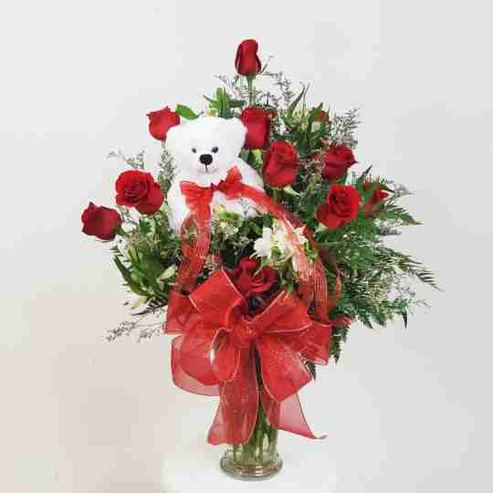 A white bear in a vase of roses 