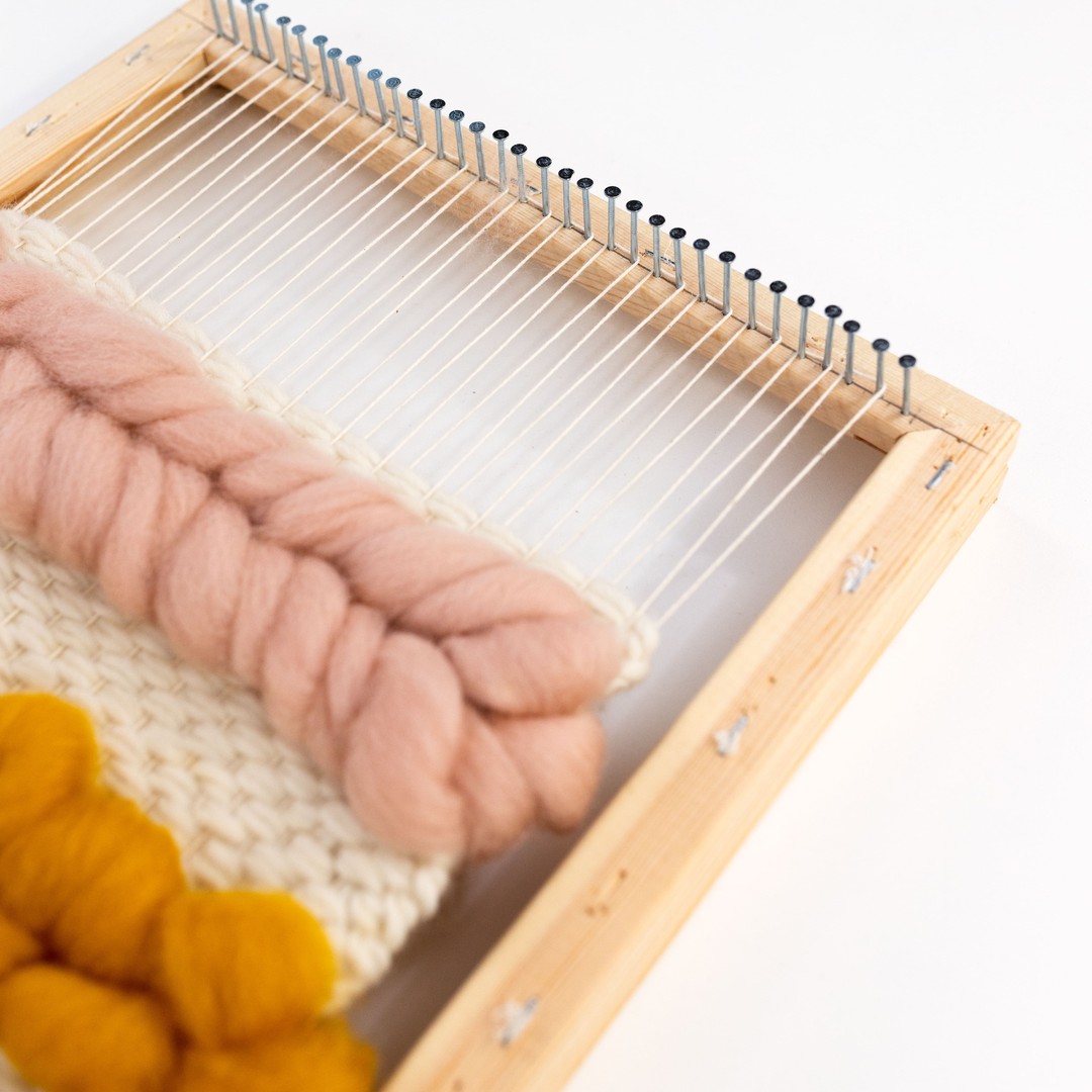 This image shows a close-up of a DIY frame loom.