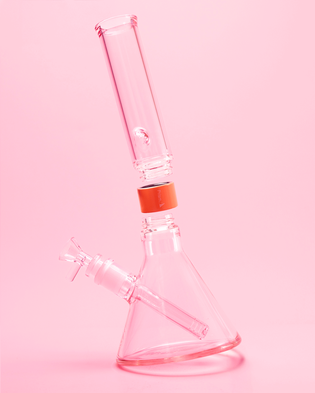 An exploded-view photograph of a Pink Lemonade Prism Mini Monochrome modular pipe. The image breaks down the complete anatomy of a compact setup, including the 14mm bowl, downstem, mini beaker base, black Halo Connector, and standard mouthpiece, illustrating how the modular system scales down for portability.