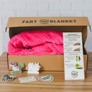 A pink dutch oven kit sits on a wood background with a recipe card and stickers. Fart Blanket