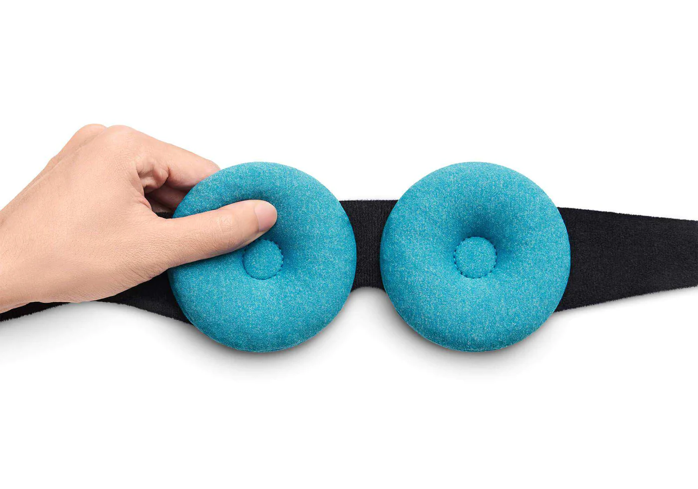 A hand pinching one of 2 blue eye cups attached to the black head strap of a cooling sleep mask with beads.