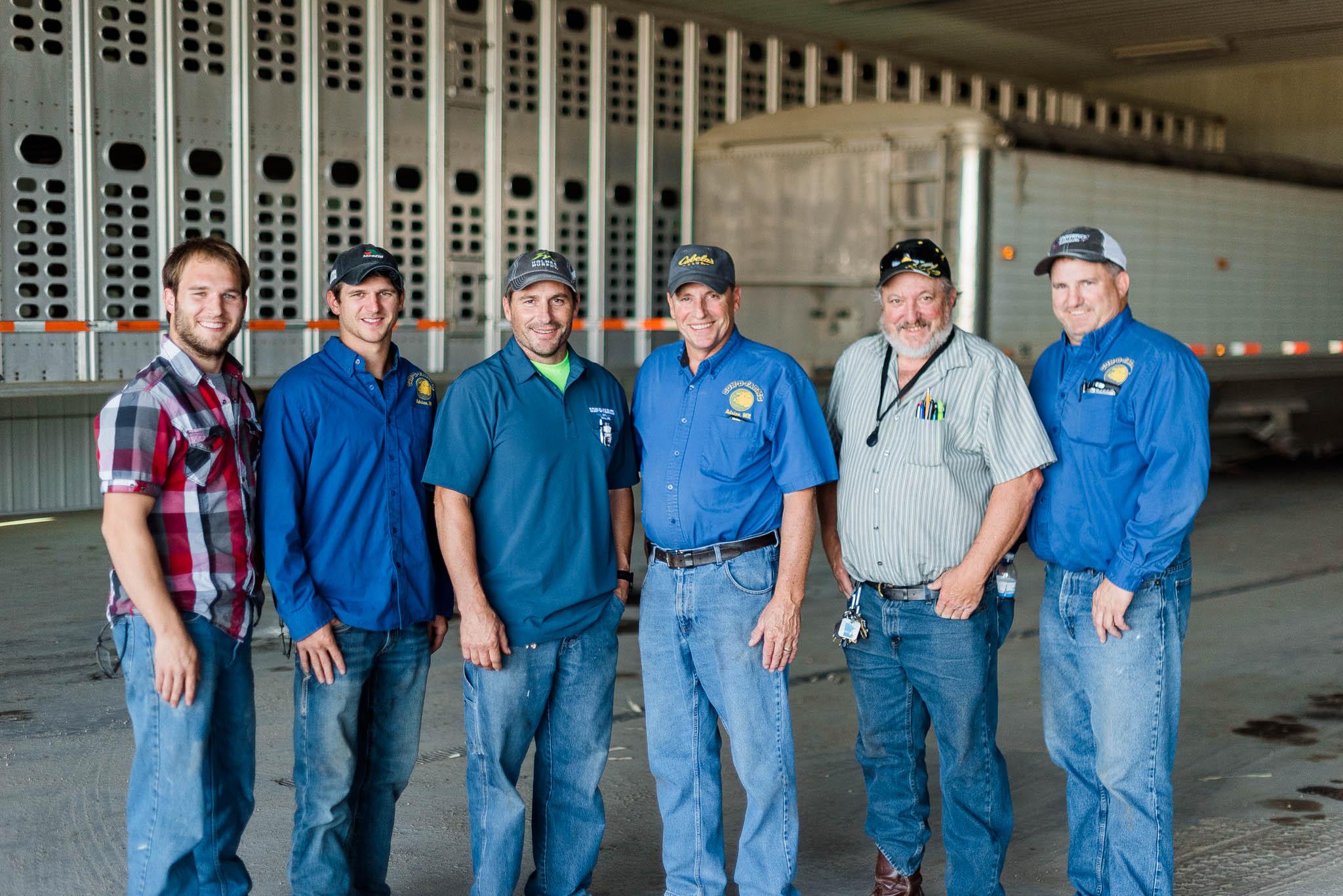 four ladies with pig masks on smiling around a pork bundle box