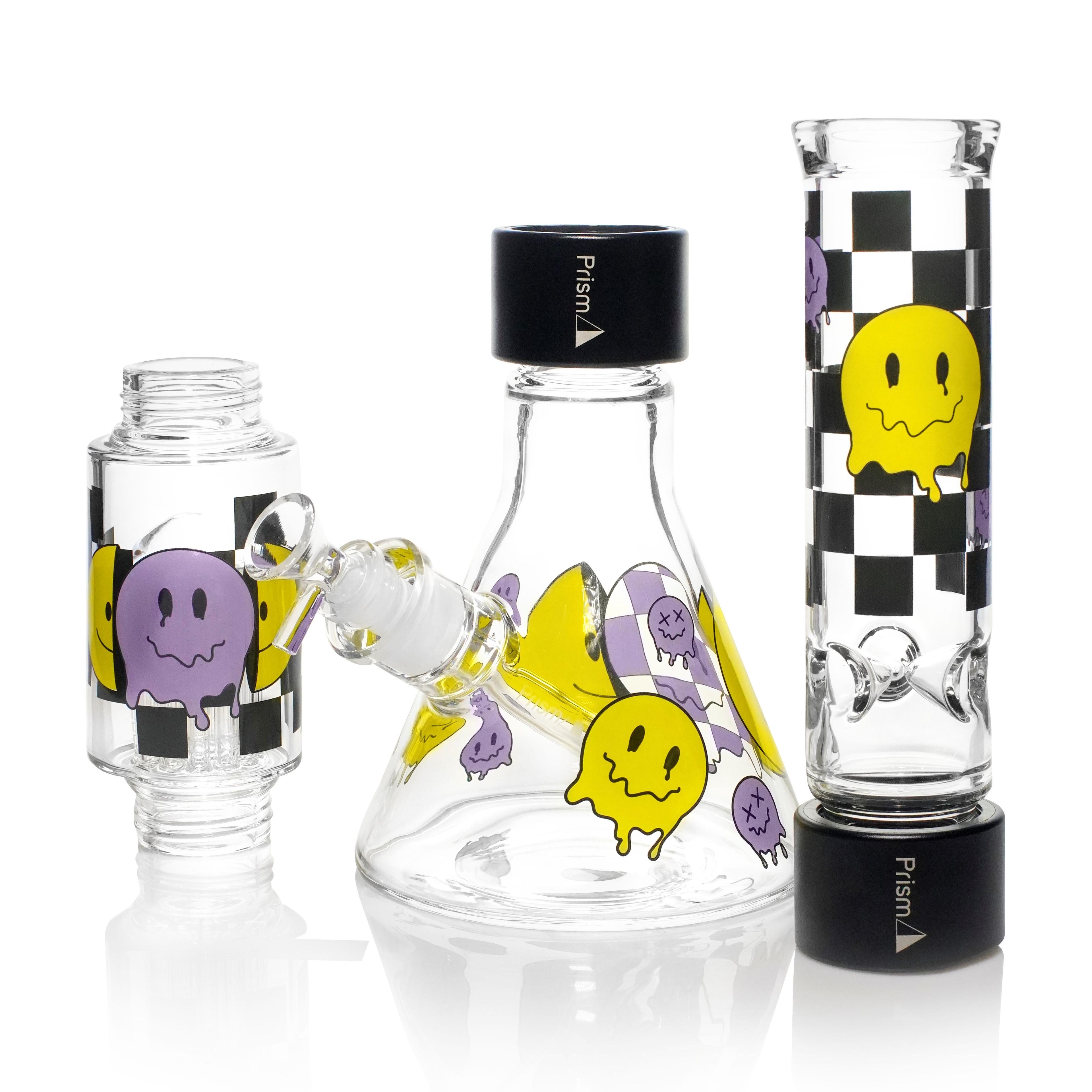 A disassembled Prism Smile Beaker Double Stack modular bong, showcasing the individual components including the purple checkered and yellow smiley face base, center percolator, and mouthpiece. The image highlights the black Halo Connectors and threaded joints, demonstrating how the modular pieces unscrew for effortless cleaning and deep-access maintenance.