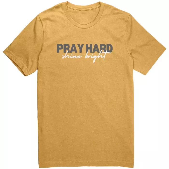 mustard yellow tee with green and white lettering, text in ceter says "Pray hard shine bright"