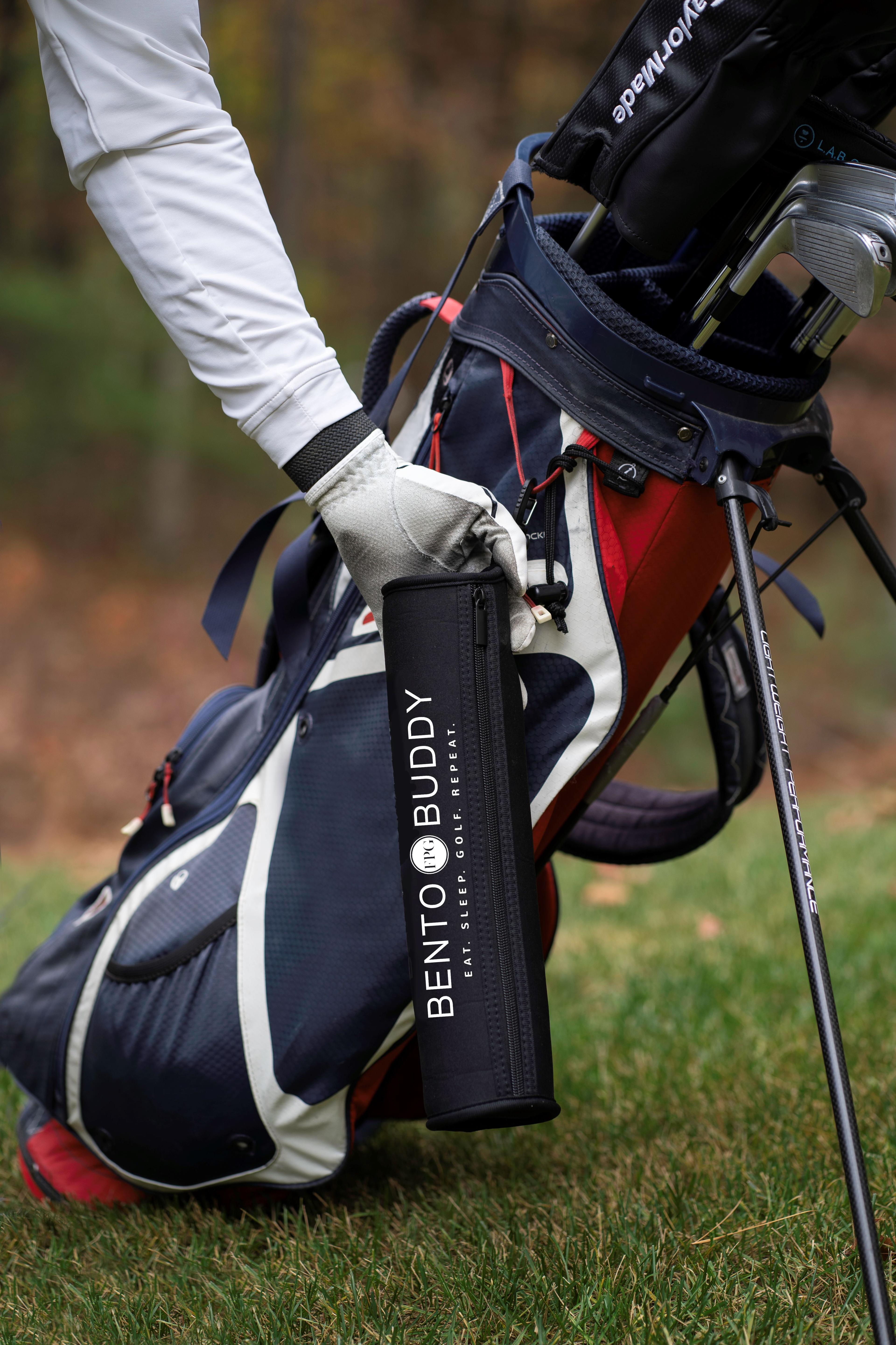 Golfer reaching for golf snack carrier attached to golf bag