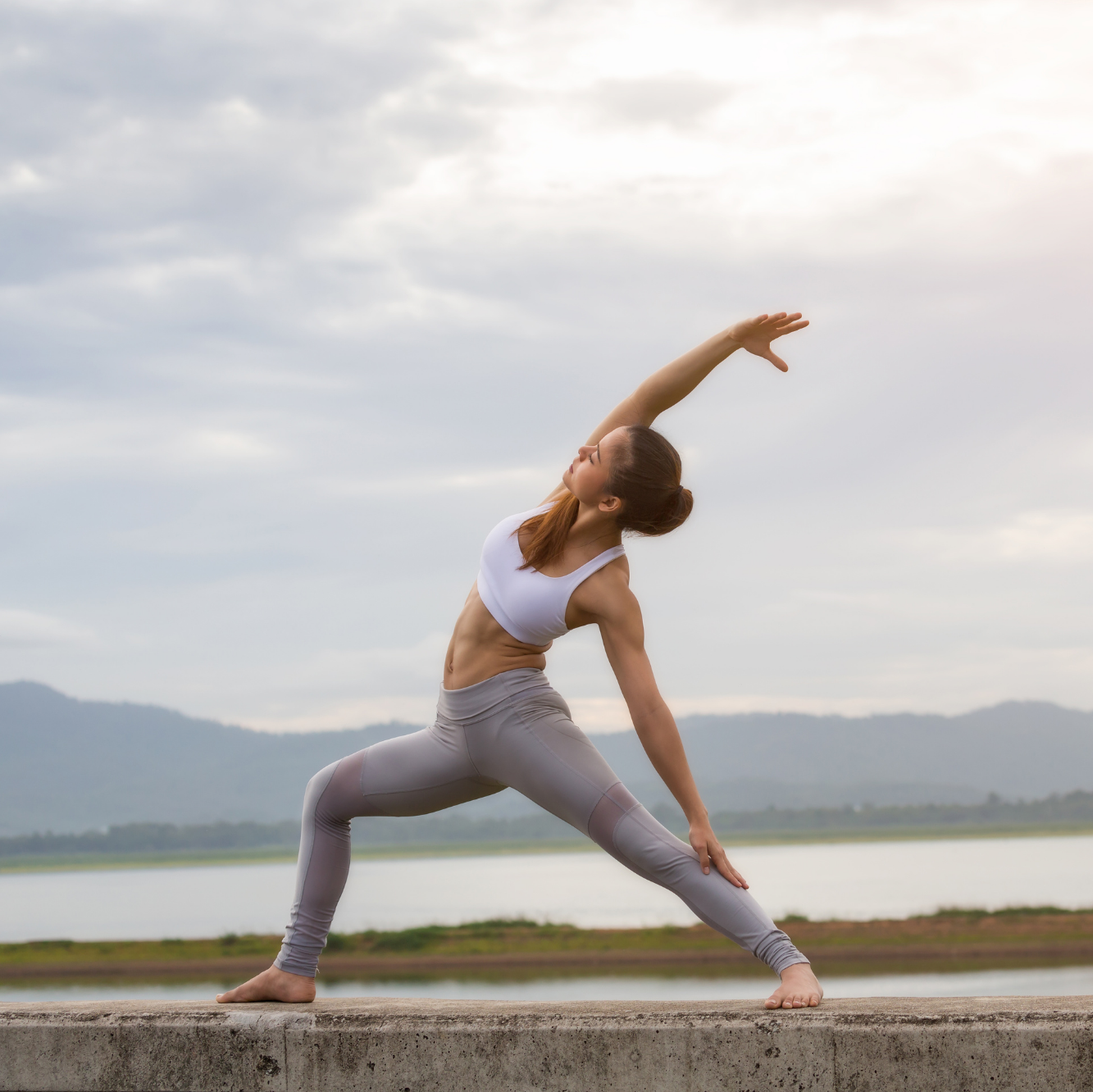 A portrait of a woman doing yoga at the beach