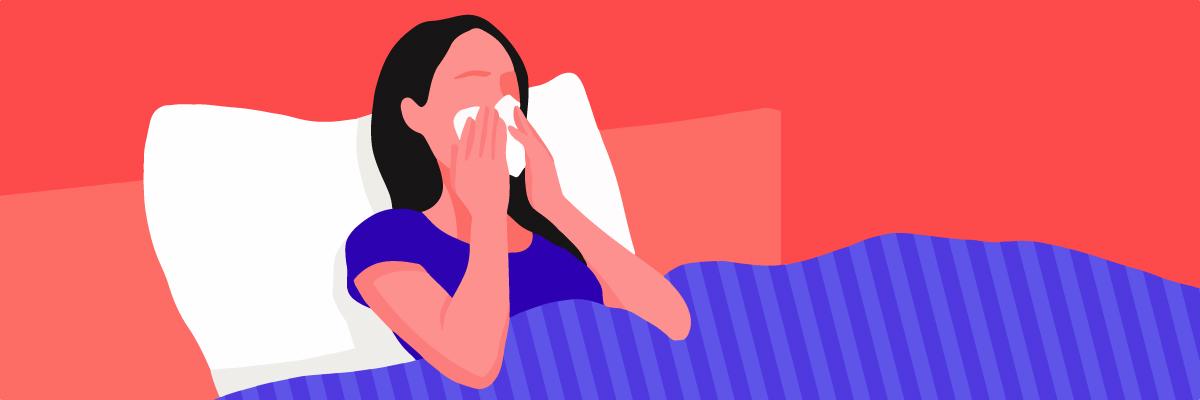 A girl with allergies, blowing her nose in bed.