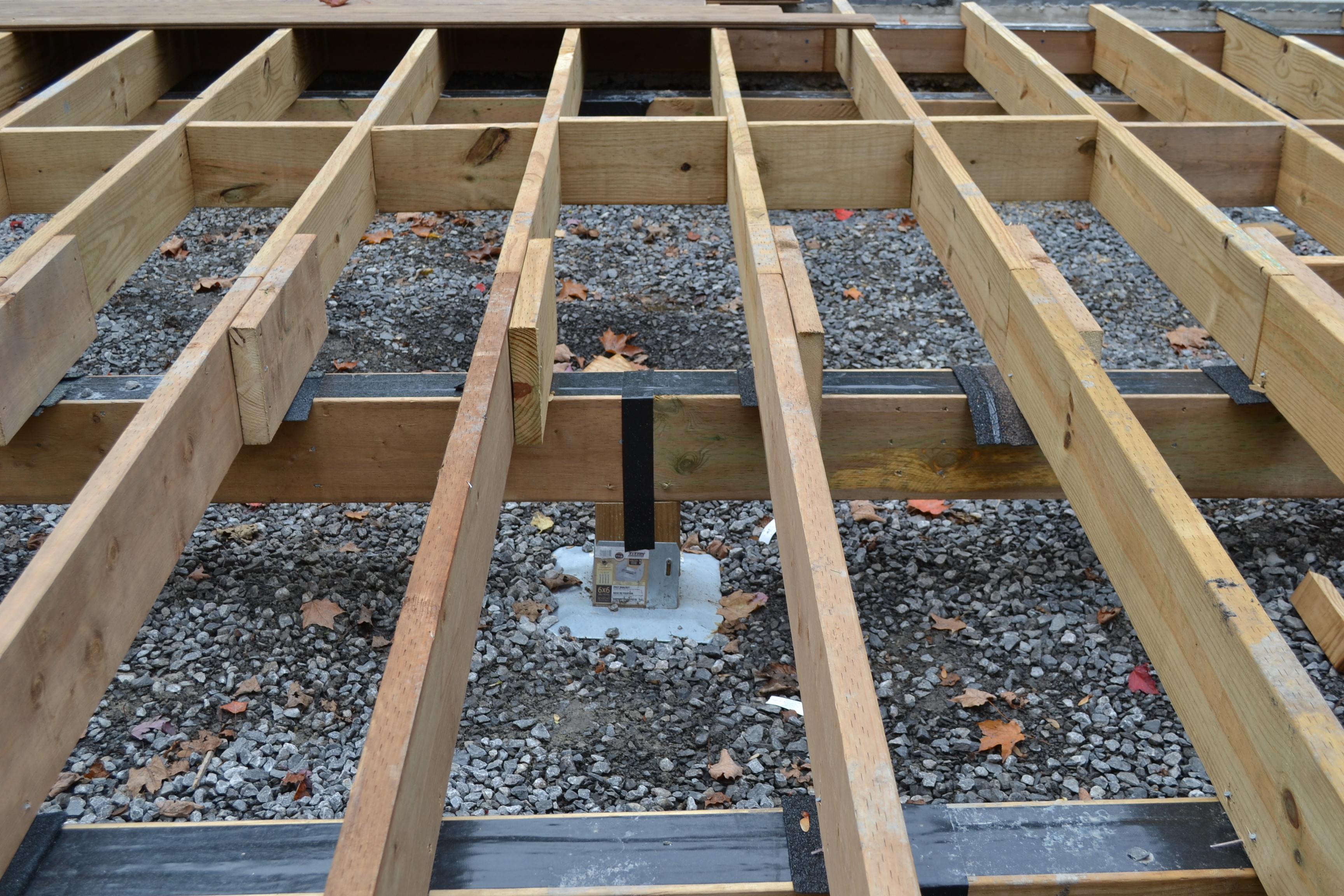 deck foot anchor in the middle of crushed stone, supporting the deck frame