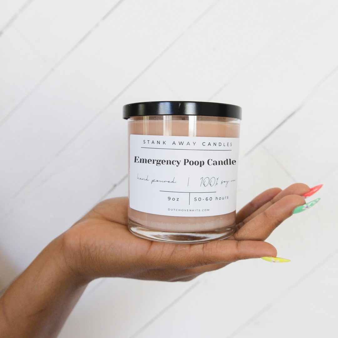 A beige candle in the hand of a woman. Emergency poop candle
