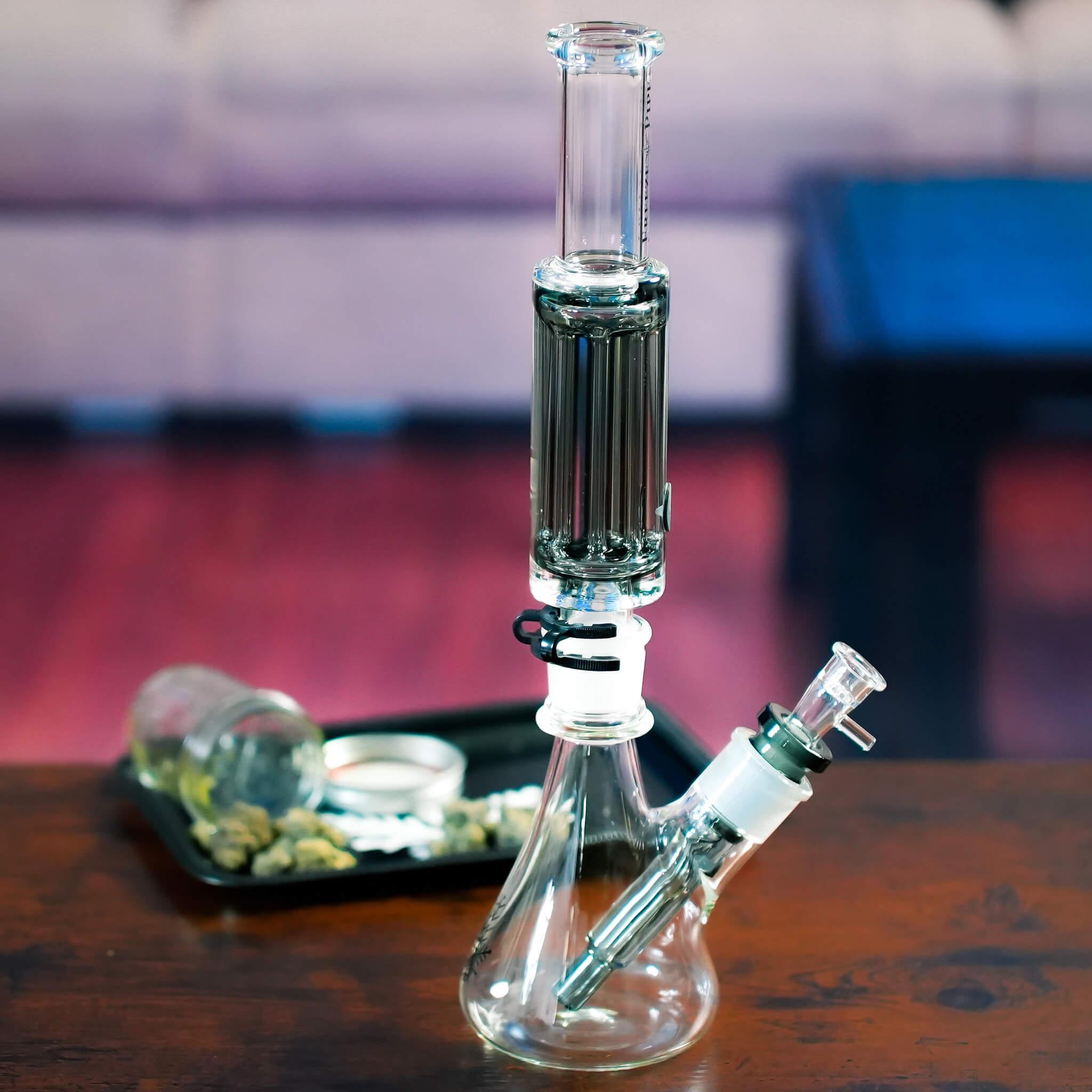 beaker bong on table with weed and rolling tray