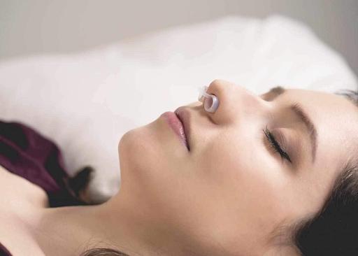 Woman wearing white anti-snore nose vents from Manta Sleep.