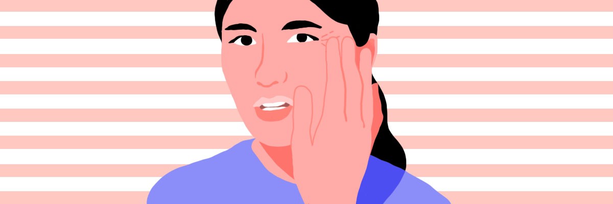 A girl examining her sleep lines, touching the side of her eye.