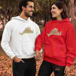 A couple holding hands wearing matching hoodies. One hoodie is red the other white