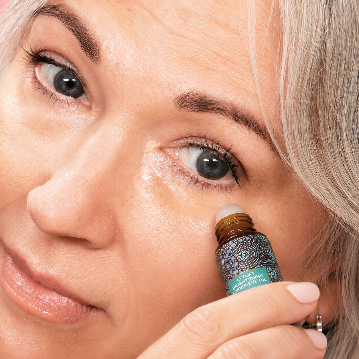 Women applying Lytlift Brightening under-eye oil