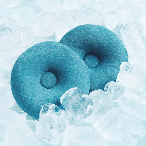 A pair of blue eye cups for a Manta Sleep mask surrounded by ice cubes.