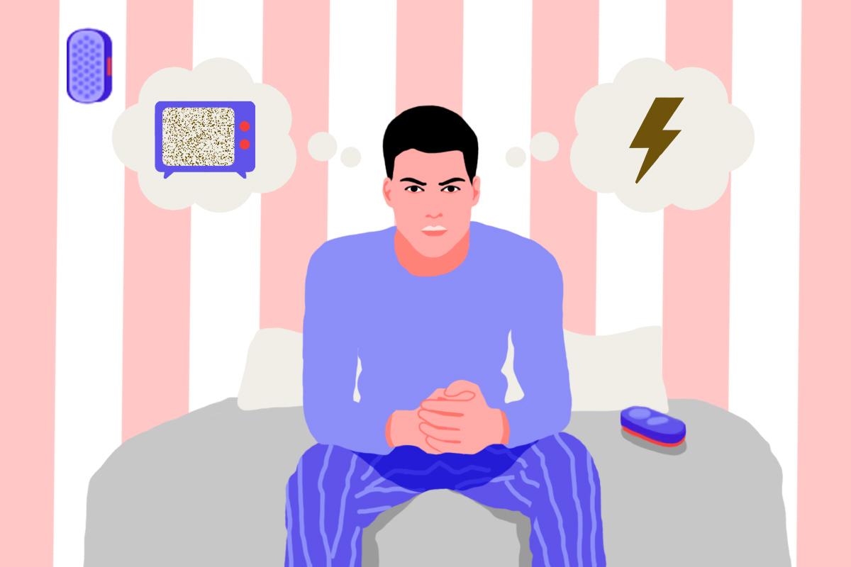 A man sitting at the foot of his bed contemplating what sound to use to sleep: white noise vs brown noise.